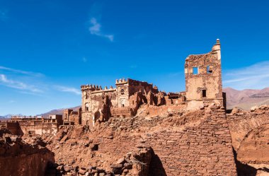 Telouet, Fas - 3 Mart 2020: Mavi gökyüzüne karşı tarihi Telouet Kasbah harabelerinin mimari detayları