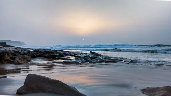 摩洛哥西撒哈拉 大西洋 潮湿的落日 沙滩上散落的岩石 — 图库照片