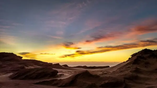 五彩缤纷的落日天空 云彩斑斑 笼罩在岩石海岸线之上 景色幽暗 — 图库照片