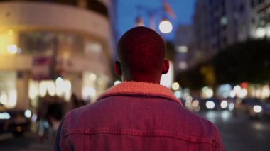 Siyah adam gece sokakta yürüyor.