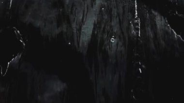 Şeffaf suyun aktığı ve siyah arkaplana karşı yavaş çekimde sıçrayan soyut arkaplan