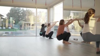 Stüdyoda yoga yaparken vücudunu esneten etek giyen esnek insanlar.
