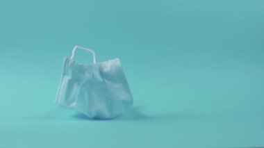 Stüdyoda mavi arka plana düşen tıbbi maskeler koronavirüsten korunma kavramını gösteriyor.