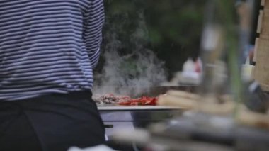 Anonim bir adamın ızgarada sebzeleri ızgarada pişirirken görüntüsü gün ışığında caddenin dışında.