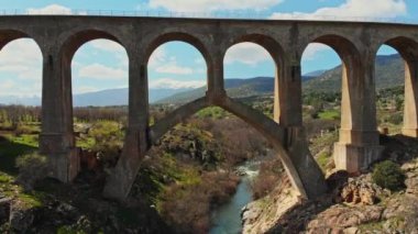 Breathtaking view of stone viaduct located in highland valley under blue sky in summer