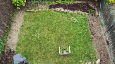 Bahçeye yeşil fidanlar eken eldivenli bahçıvan.