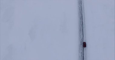 Karlı arazide araba sürüyor.