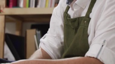 Erkek terzi, ölçüm bandı kullanırken, modern atölyedeki müşteriler için özel dikim kıyafetler yaparken kalıpların tam boyutlarını kontrol ediyor.