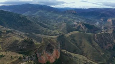 Pan around drone view of majestic highland valley with settlement with residential buildings on sunny day in Islallana