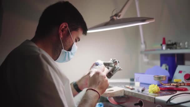 Zijaanzicht Van Geconcentreerde Mannelijke Tandtechnicus Onderzoeken Gips Gegoten Kaken Articulator — Stockvideo
