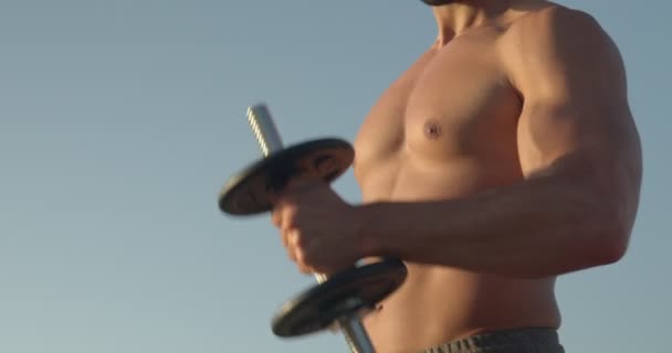 夏天站在蓝天下用哑铃做运动的无名氏男性运动员 — 图库视频影像