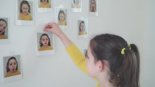 小女孩把照片贴在房间的墙上 — 图库视频影像