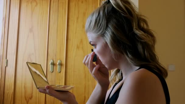 カラフルな目の影と鏡を持つ若い女性がパレットを保持し 自宅での美しさの手順中にまつ毛に黒マスカラを適用 — ストック動画