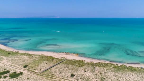 夏の晴れた日には 砂浜と透明な海の水が岩の崖に囲まれて青いラグーンを飛んでドローンビュー — ストック動画