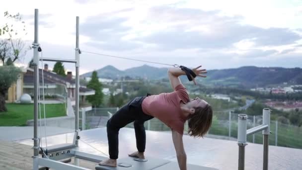 Side View Flexible Male Standing Urdhva Dhanurasana Straps Pilates Machine — Stock Video