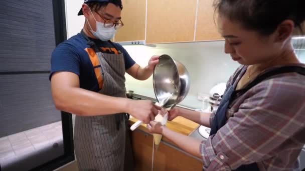 그릇에서 반죽을 긁어내어 파이프 제과점에서 일하도록 아시아 — 비디오
