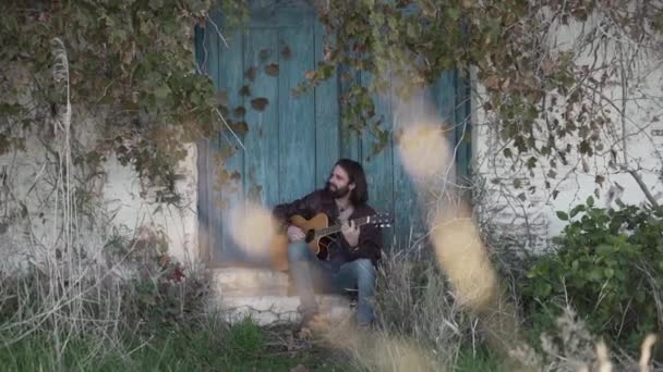 Musician Sitting Playing Guitar While Looking Away — Stock Video