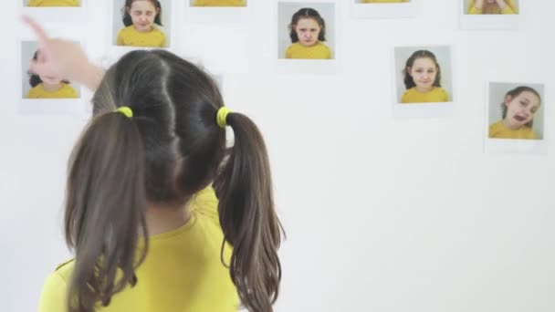 Маленька Дівчинка Наклеює Фотографії Стіну Своєї Кімнати — стокове відео