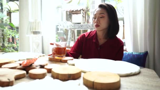 在台湾 年轻的亚洲女性游客坐在餐桌旁享用早餐和热茶 而在舒适的房间里与传统东方风味的东西一起休息 — 图库视频影像
