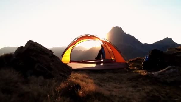 Камера Приближается Через Палатку Расположенную Рядом Туристом Сидящим Холме Любующимся — стоковое видео
