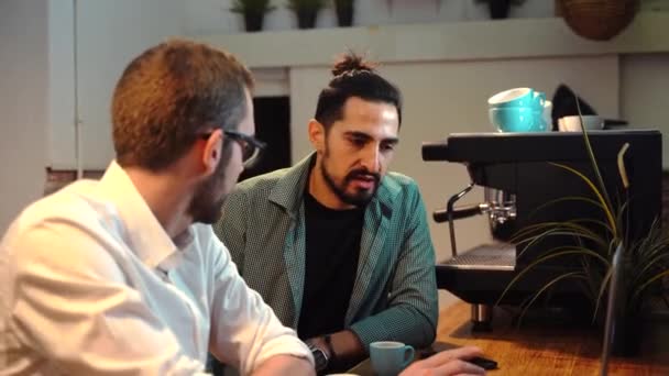 Αρσενικό Baristas Κάθεται Πάγκο Φορητό Υπολογιστή Στο Καφέ Και Μιλάμε — Αρχείο Βίντεο