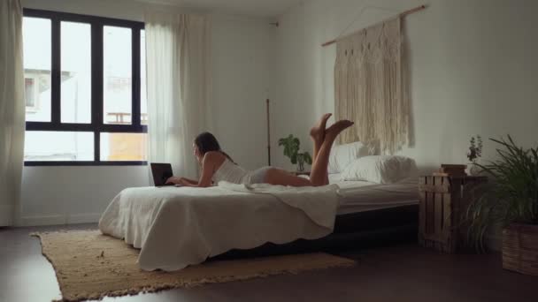 Cheerful Millennial Female Nightwear Lying Bed Surfing Internet Laptop While — Vídeo de Stock