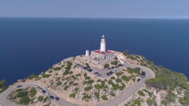 Kavisli yolu olan kayalık deniz kıyısındaki deniz feneri.