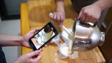 Yukarıdan bir kadın cep telefonuyla ekin toplayan adamın evde birlikte yemek yaparken fotoğrafını çekiyor.