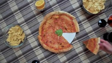 Masadaki tanınmayan kadının en iyi görüntüsü ve hafta sonunun tadını çıkarırken evde lezzetli pizzalar yemek.