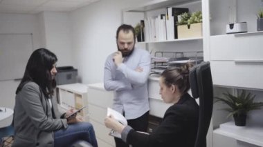 Genç erkek, modern çalışma alanındaki kadın iş arkadaşlarıyla toplantıda.