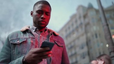 Siyah adam akıllı telefonlara bakıyor.