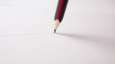 Beyaz kağıda gerçek zamanlı olarak düz çizgi çizen grafit kalem yakın plan