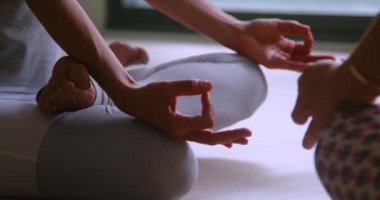 Spor giyimli bir grup kadın Lotus 'ta yerde oturmuş yoga dersi sırasında meditasyon yapıyorlar.
