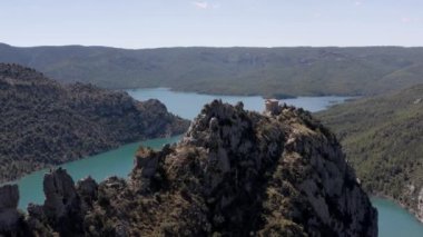 Breathtaking aerial view of calm blue lake surrounded by green rocky cliffs on sunny day