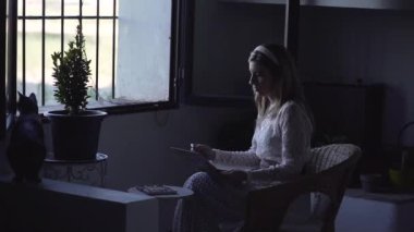 Huzurlu kadın günlükte resim yapıyor, sandalyede oturuyor.