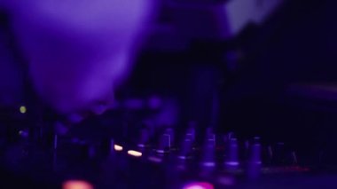 Modern bir kulüpte gece partisinde müzik karıştıran isimsiz bir disk jokeyi.