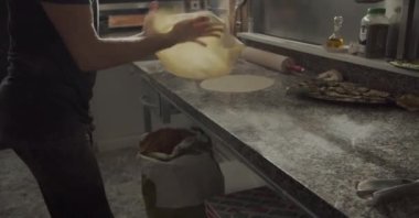 Mahsul erkek aşçı un tozu masasında pizza pişirirken hamur esnetmeye başlıyor.