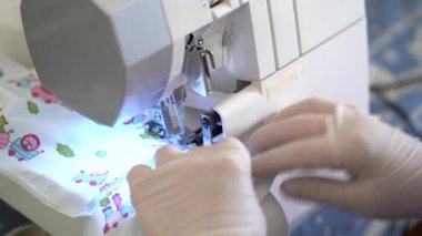 İş yerinde koronavirüs önleme için kumaş maskeleri diken lateks eldivenli tanınmayan terzinin yan görünüşü