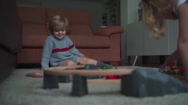 곱슬머리의 동생들 거실에서 시간을 보내면서 바닥에 장난감 도로와 자동차를 가지고 — 비디오