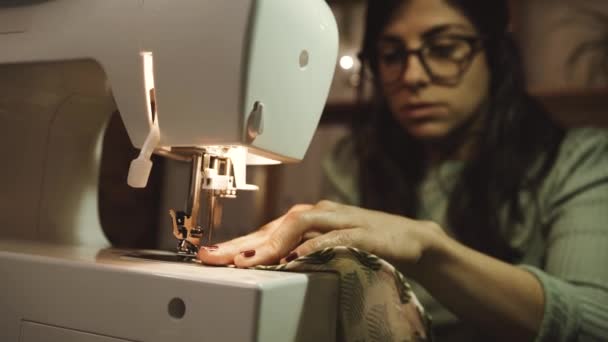 车间木桌上使用带线轴的现代金属缝纫机时 种植严重的民族女手艺人拉长细线 — 图库视频影像