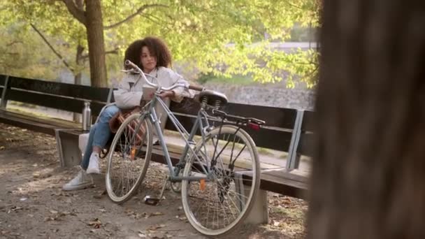 Calma Mujer Afroamericana Con Pelo Rizado Sentado Banco Cerca Bicicleta — Vídeo de stock