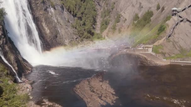 強力なモンモランシーの息をのむような景色の上から滝は遅い動きで見られるカナダのケベック州で夏の日に水の中の虹と高い岩の崖からストリーミング — ストック動画