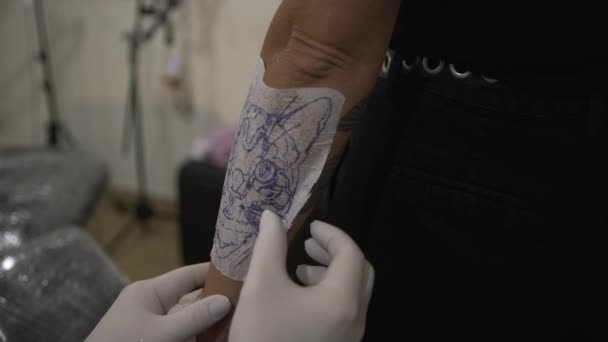 Anonimowy Męski Tatuażysta Przenoszący Szablon Tatuażu Ramię Klienta Salonie — Wideo stockowe