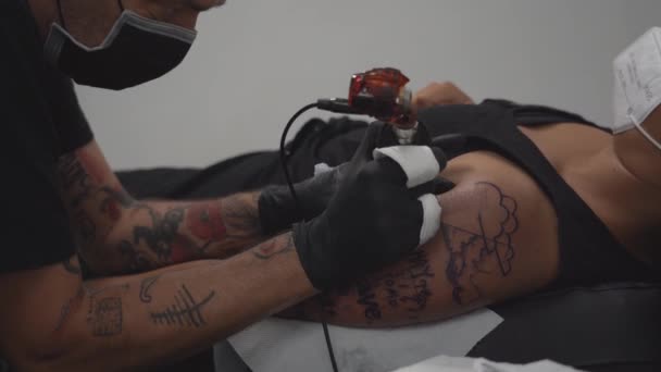 Crop Male Tattooist Machine Making Tattoo Arm Woman Lying Table — Stock Video
