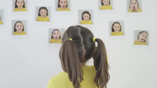 部屋の壁に写真を貼ってる女の子 — ストック動画