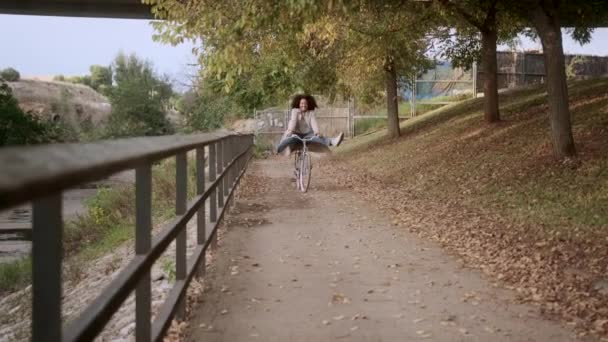 Lekfull Afroamerikansk Kvinna Ridning Cykel Med Upphöjda Ben Höst Park — Stockvideo
