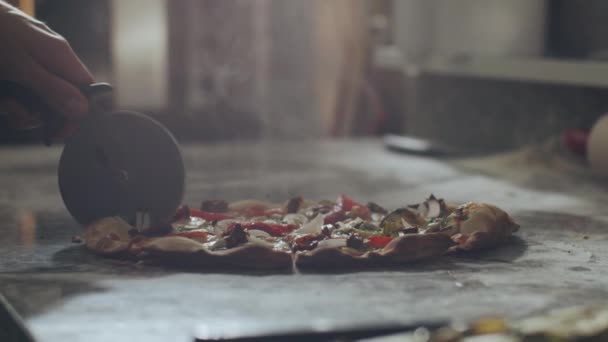 レストランキッチンで作業しながら 大理石のカウンターで焼きたての食欲をそそるホットピザを切断ミステリー匿名のピザメーカー — ストック動画