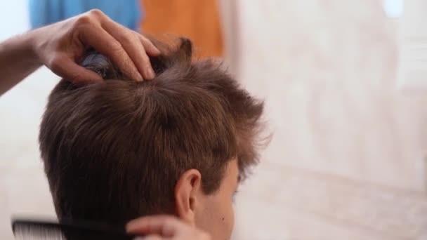 Земледелец Расчесывает Волосы Молодого Парня Делает Прическу Светлой Ванной Комнате — стоковое видео