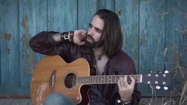 Músico Sentado Tocando Guitarra Mientras Mira Hacia Otro Lado — Vídeo de stock