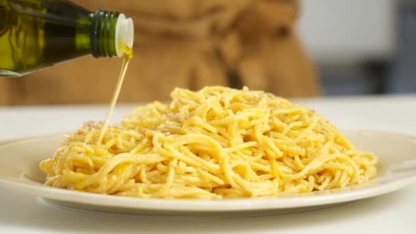 自家製のランチを提供しながら おいしいイタリアのスパゲティパスタとプレート上にオリーブオイルをこぼす作物の匿名の人の閉鎖 — ストック動画